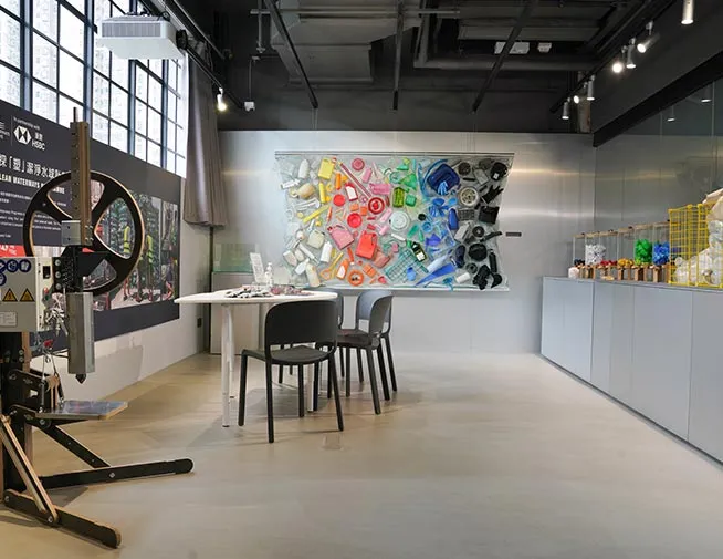 Recycling workshop room with equipment and a wall display of recovered objects