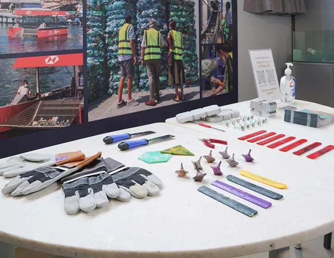 Gloves, tools and colourful recycled plastic objects on a workshop table