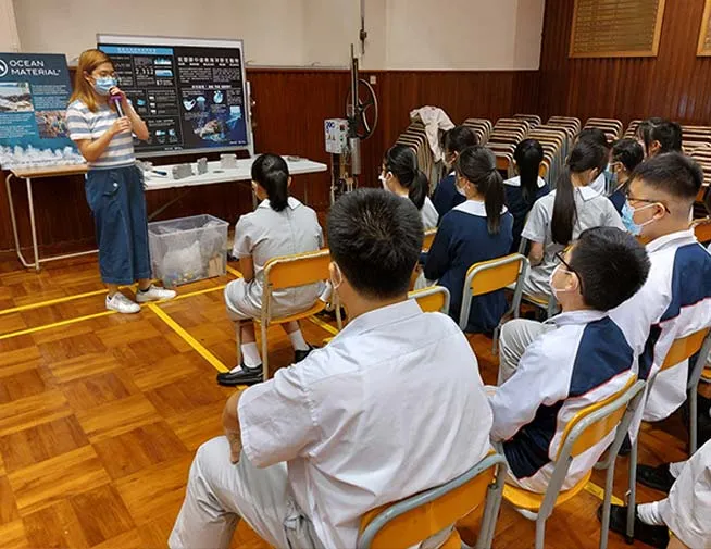 Presenter speaking to seated students at a recycling workshop