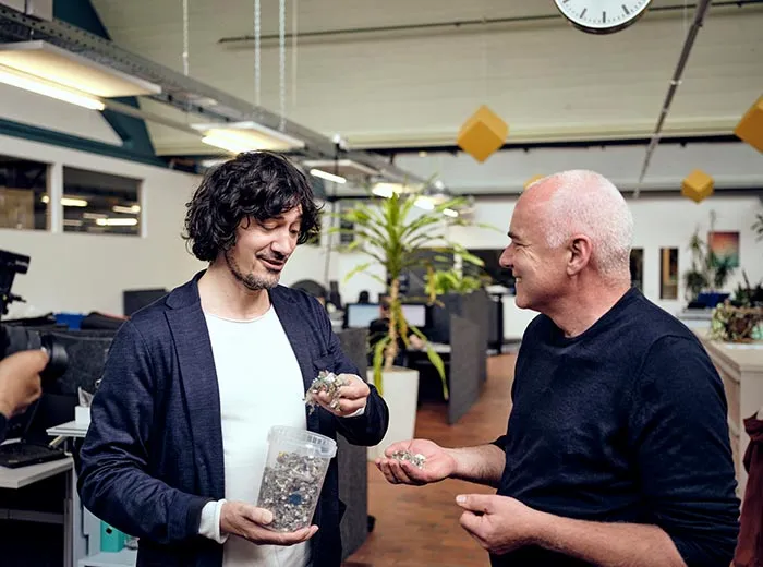 Two engineers discussing a sample of shredded plastic residue