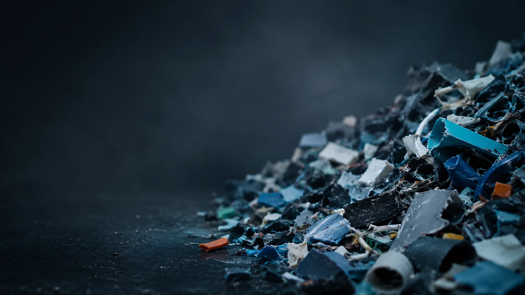 Illustrative image of mixed plastic fragments on a dark background